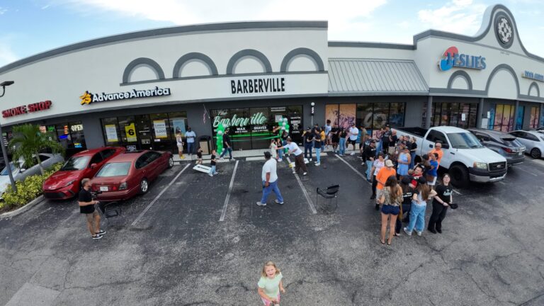 Crowd celebrating the Barberville barbershop grand opening, drone view
