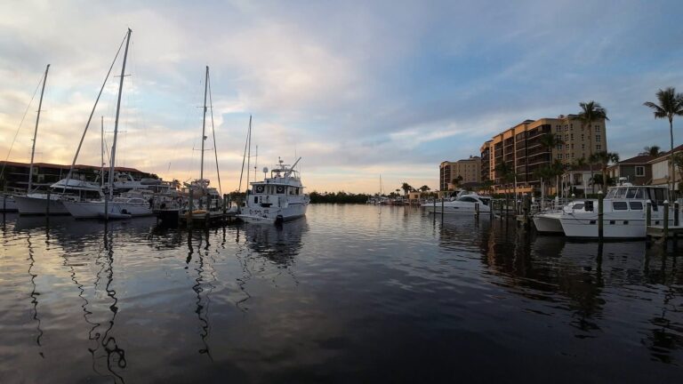 Yachts reflected in calm water at Burnt Store Marina at golden hour