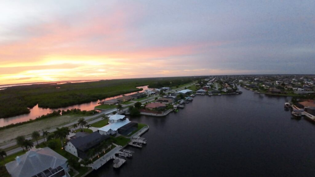 Pink sunset over Cape Coral canal homes and mangroves from the air