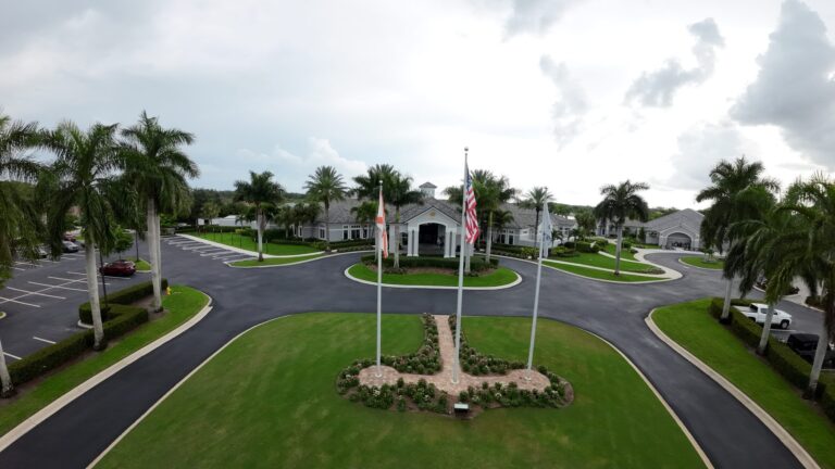 Colonial Country Club clubhouse entrance with flags, aerial view