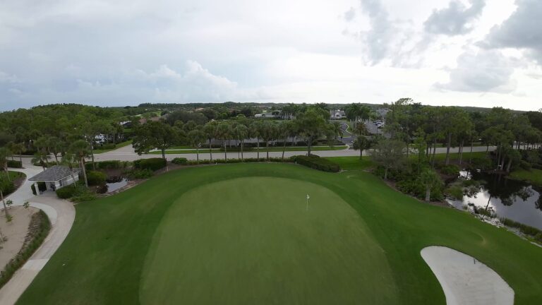 FPV drone flying over a putting green and bunker at Colonial Country Club