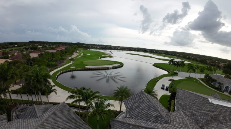 Tile rooftops overlooking a golf course lake, drone view