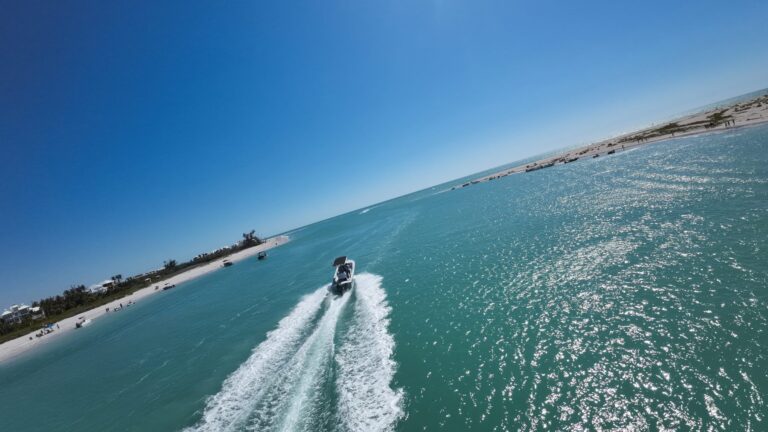 Nauti Dawg Charters boat carving a white wake across turquoise water